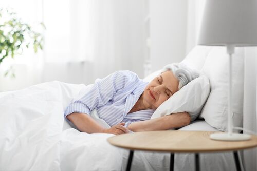 Elderly woman sleeping on electric adjustable bed