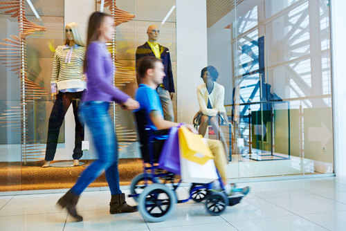 mans seated in a transit wheelchair inside a shopping mall